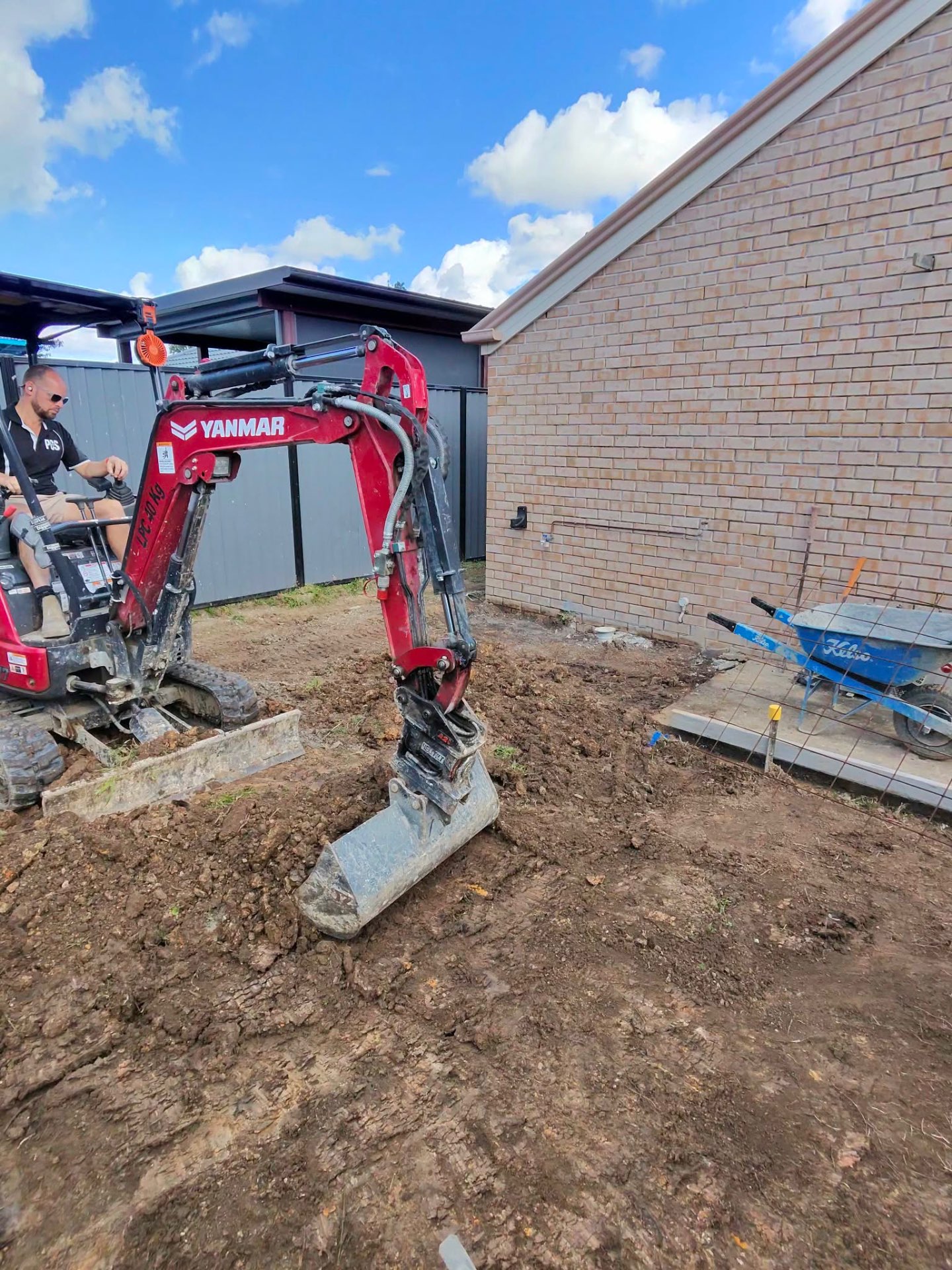 PCS excavator preparing a backyard before a concrete pour